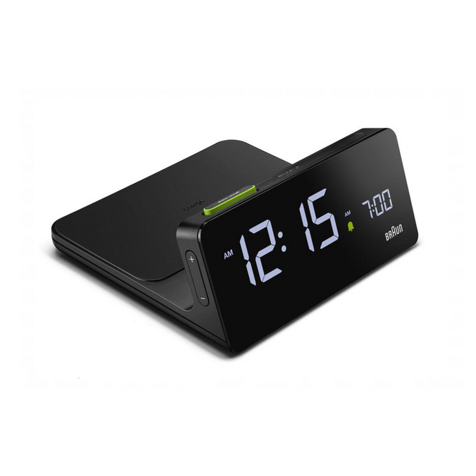3/4 view of black digital clock against a white background. The charging dock is attached behind the clock. The clock face is black and can be illuminated.