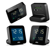 Load image into Gallery viewer, 4 angled views of square black digital clock against a white background. The clock face is black and has illuminated numbers. The profile is slim with a battery compartment acting as a stand.
