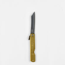 Load image into Gallery viewer, A vertical view of an open folding knife, the handle is brass with Japanese kanji characters.
