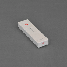 Load image into Gallery viewer, Angled view of a white gift box for the knife, with a red logo and minimal Japanese text on a grey background.
