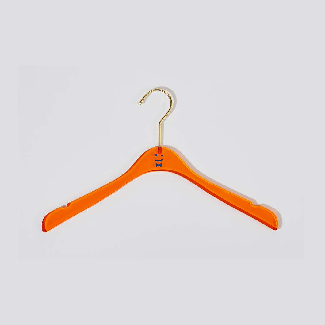 Straight on view of an orange acrylic hanger with a blue smiley face and bowtie in the middle and a gold hook.